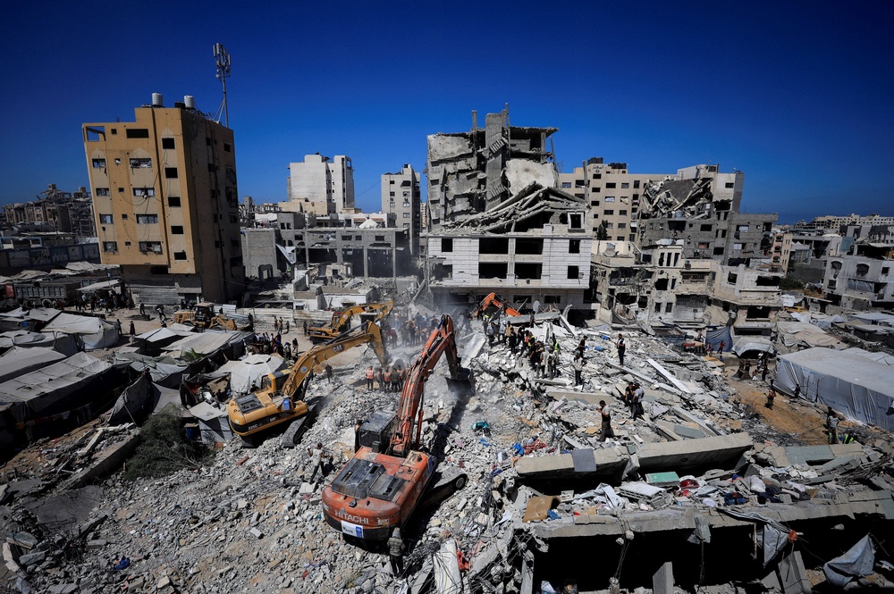 Search teams race to save people trapped beneath the rubble of a collapsed residential building in Gaza last week. The building had been damaged in an earlier Israeli strike during the war (Reuters)