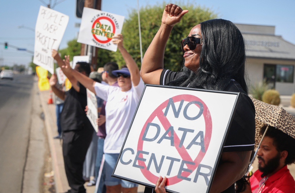 Demonstrators wave signs in Imperial, California, during a nationwide protest against AI data center expansion on July 18, 2026 (AFP via Getty Images)