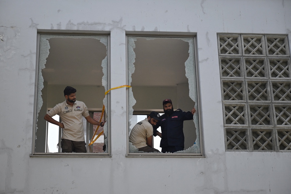 Police look on from shattered windows at the scene following a fire outside the Mother and Child Health (MCH) ward at the Pakistan Institute of Medical Sciences (PIMS) Hospital in Islamabad (AFP/Getty)