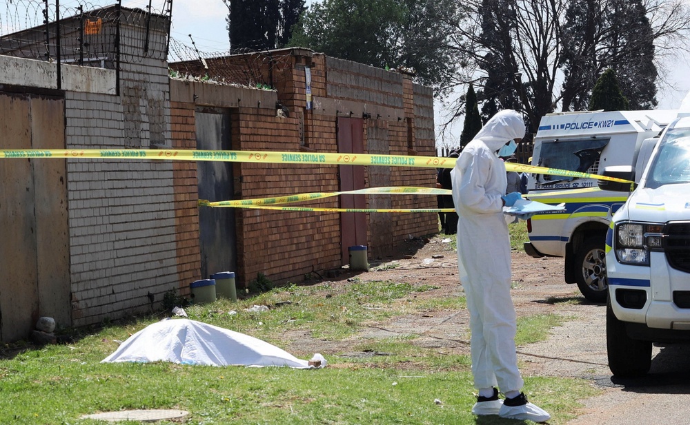 A forensic investigator works near a cordoned-off crime scene in Ekurhuleni, east of Johannesburg (Reuters)