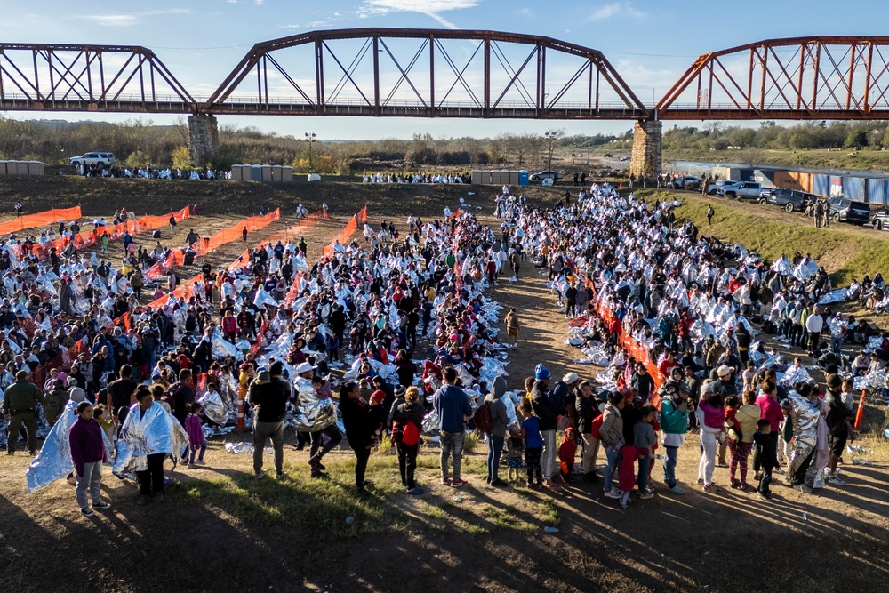 Thousands of immigrants, most wearing thermal blankets, await processing at a U.S. Border Patrol transit center on December 19, 2023 in Eagle Pass, Texas (Getty Images)