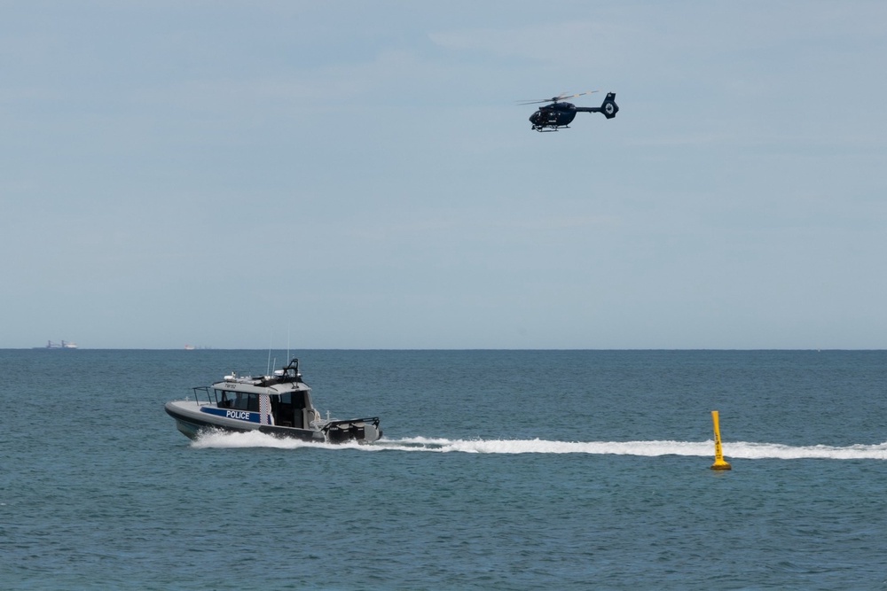 A police boat and helicopter patrol the area at Sorrento Beach (AP)