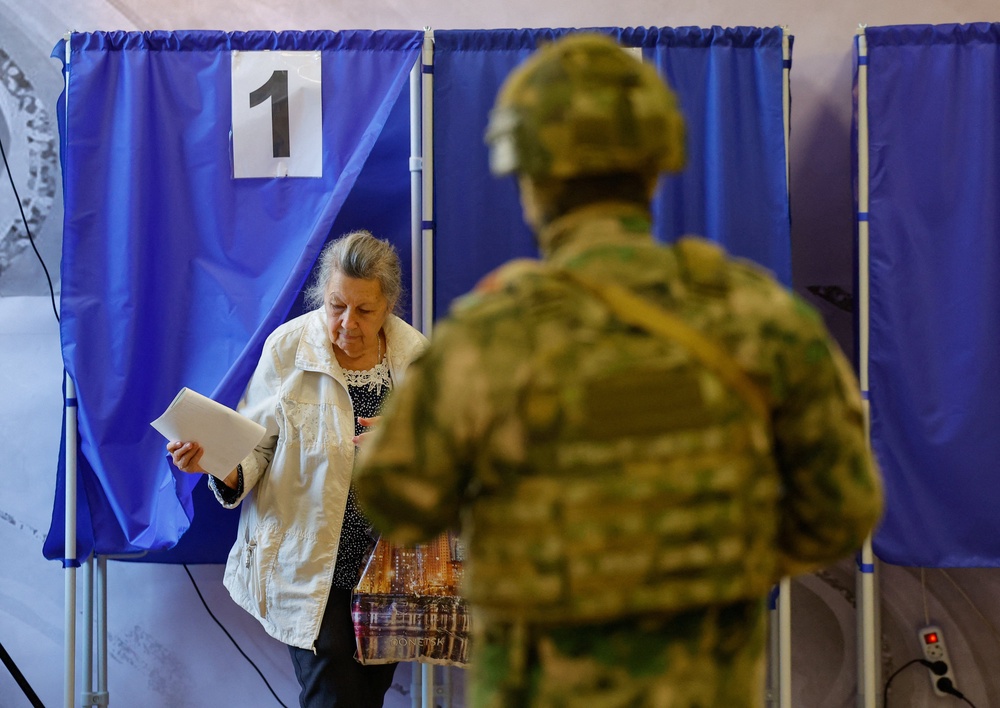 A woman leaves a voting booth with her ballot in Donetsk, Russian-controlled Ukraine, September 18, 2026 (Reuters)