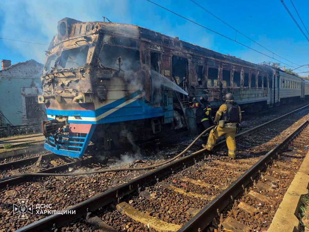 Firefighters extinguish fire on a suburban train which was hit by a Russian drone strike in Kharkiv region (Reuters)