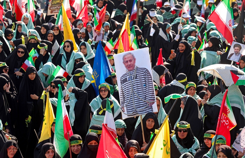 A woman holds a placard depicting Israeli Prime Minister Benjamin Netanyahu during the rally (AFP via Getty Images)
