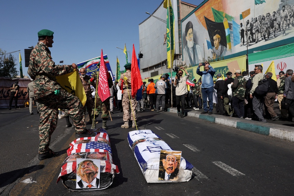 Coffins with images of  U.S. President Donald Trump and Israeli Prime Minister Benjamin Netanyahu during a military march in Tehran (Reuters)