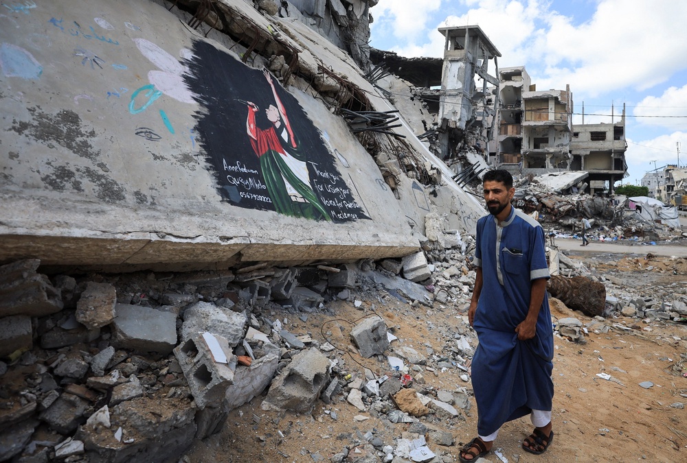 Palestinian walks past a mural painted in honour of American rapper Macklemore (Reuters)