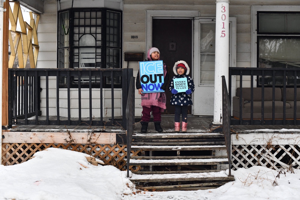 Children hold signs on the stoop of a house as protesters march from Powderhorn Park in Minneapolis against Immigration and Customs Enforcement (ICE) and the fatal shooting of Renee Good by an ICE agent. Beyond chronic absenteeism, teachers describe students shutting down mid-exam or crying during class during peak winter operations (AFP via Getty Images)
