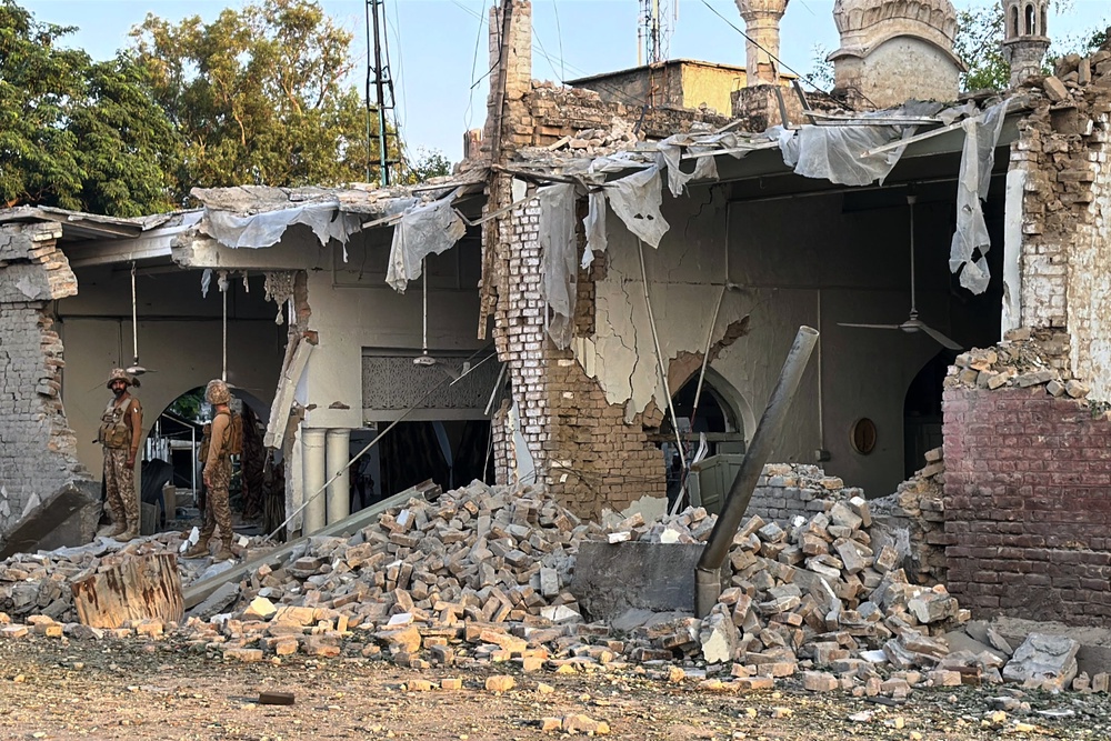 Army soldiers stand over the rubble at the site of a powerful bomb exploded at a mosque in Kohat, in northwestern Pakistan (AP)