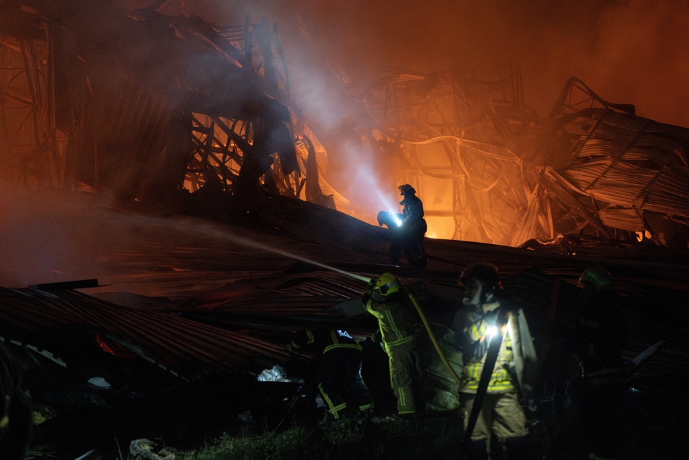 Ukrainian firefighters extinguish a fire at a warehouse following a Russian drone strike in Kyiv region on 20 September 2026 (AFP/Getty)