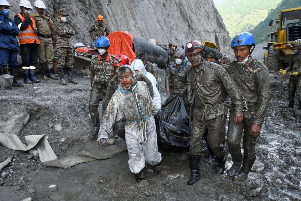 Nepalese soldiers carry the bodies of workers recovered during a search and rescue operation at the Chilime hydropower project following flash floods in Rasuwa (AP)