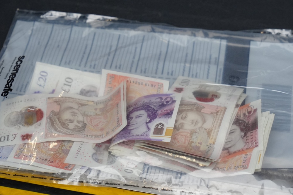 Cleveland Police officers seize cash during a raid on a property in South Bank, as part of Operation Artemis (PA)