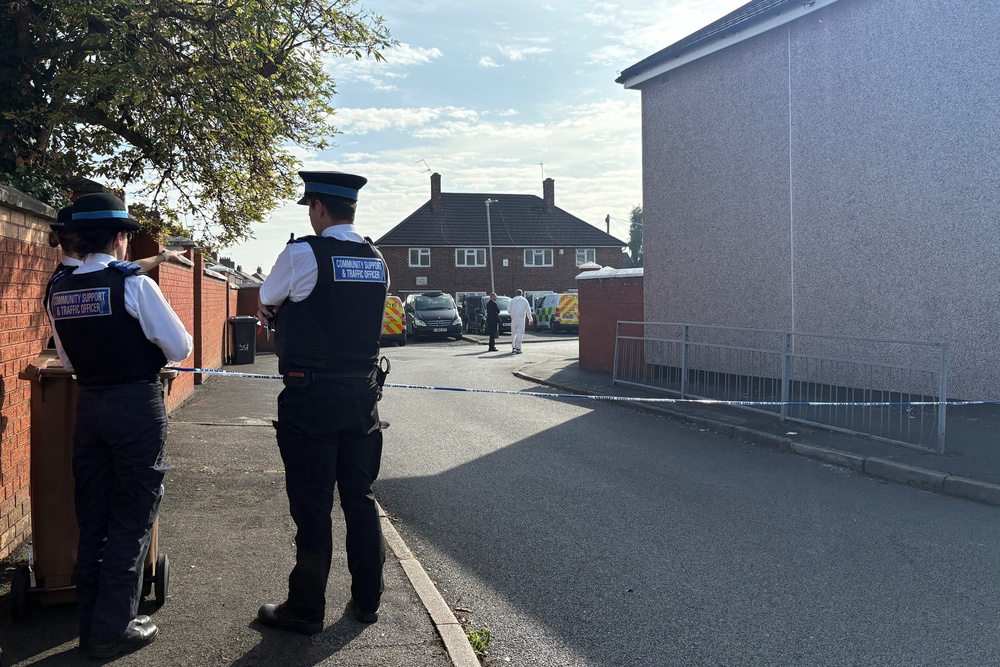 Police officers on the scene after the fatal fire (PA)