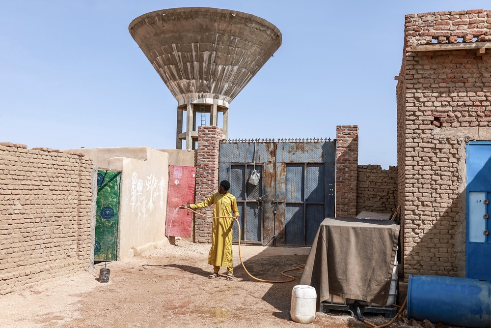 Faisa Ismail holds a water hose in the courtyard of their home in Abeche. In Chad's east, a 'dire need' for water blights lives and fuels deadly violence over access to wells (AFP/Getty)