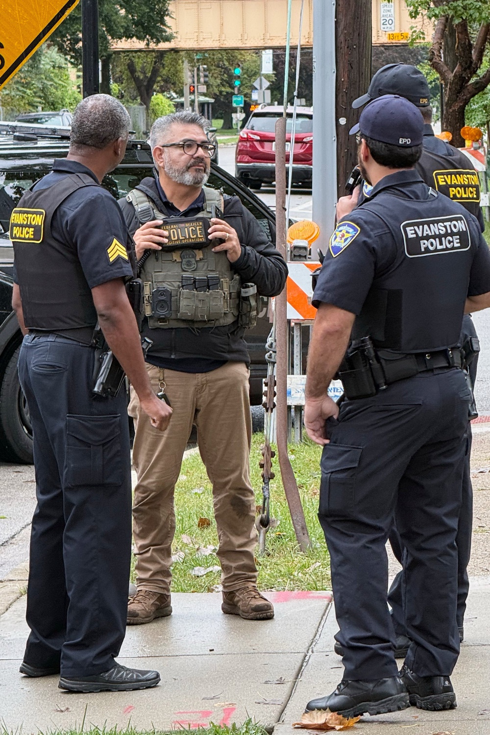 This photo taken with a smartphone and provided by Ryan Garton shows a federal officer speaking to Evanston, Ill., police officers (Ryan Garton)