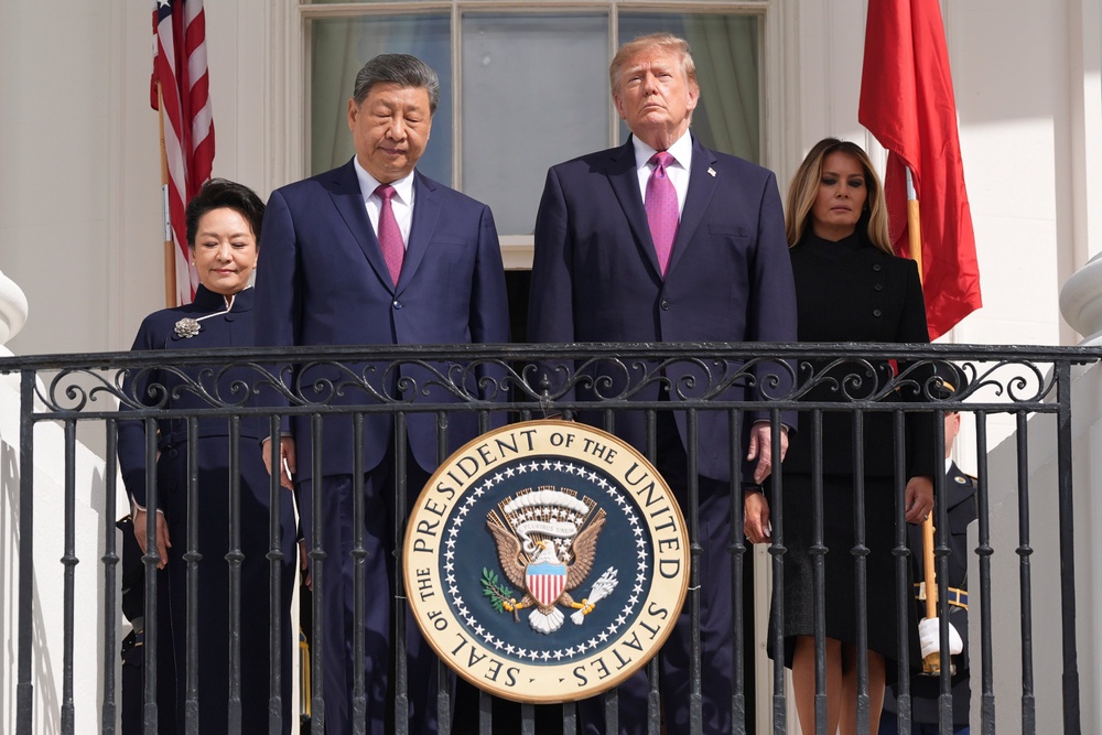 Trump with his wife, first lady Melania Trump, stands next to Xi and his wife Peng Liyuan as they watch a drill platoon review on the new helipad from the Blue Room Balcony (AP)