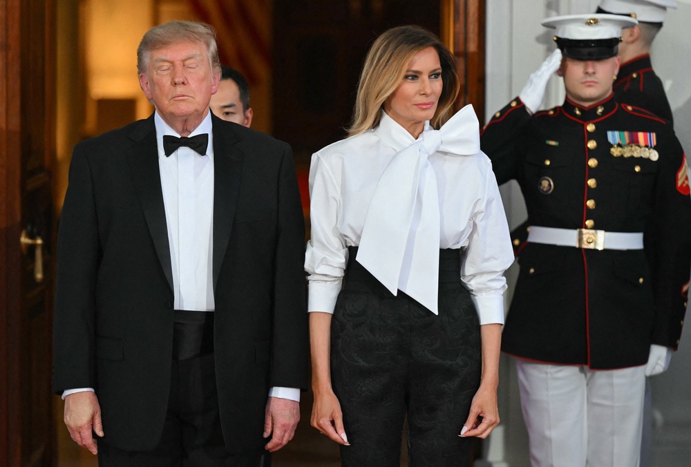 Trump was photographed, with makeup caked on his left hand used to cover bruising, next to first lady Melania Trump while waiting to greet Xi and his wife Liyuan Peng at the White House ahead of the dinner (AFP via Getty Images)
