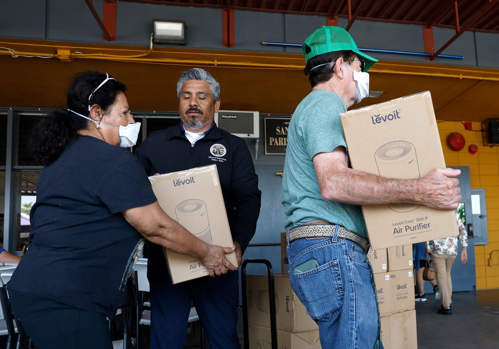 Antonio Chapa hands out free air purifiers during a health services pop-up in Los Angeles on 23 June 2026 (Getty)