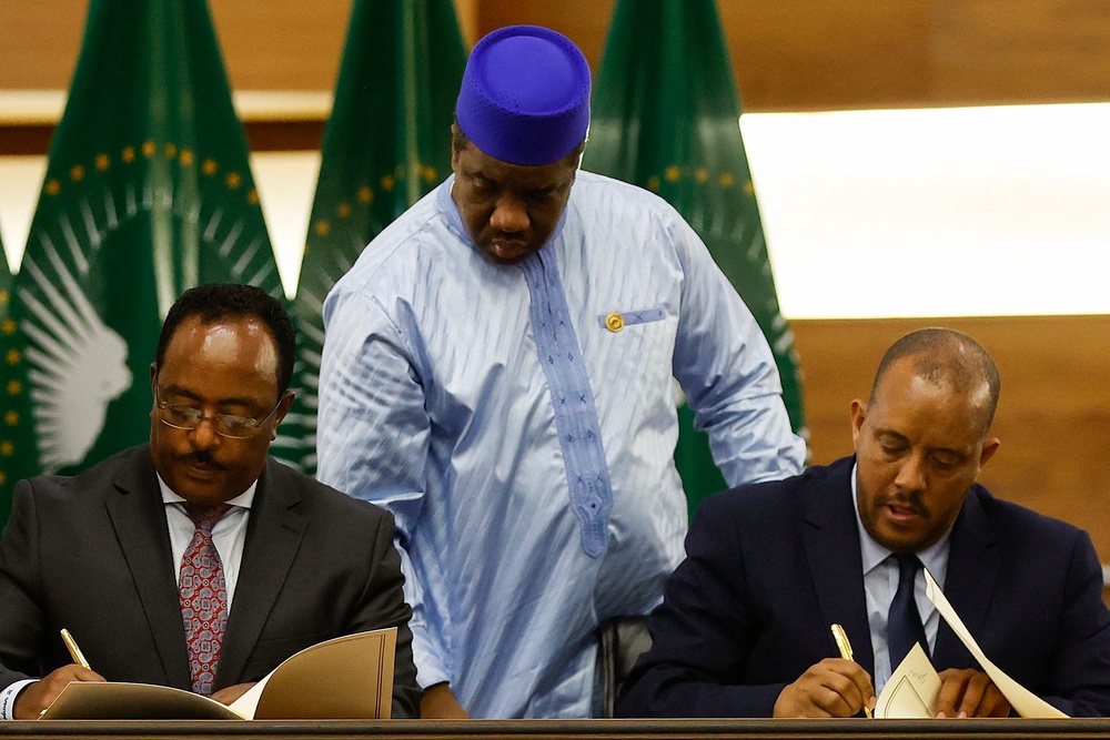 Redwan Hussein (L), Representative of the Ethiopian government, and Getachew Reda (R), Representative of the Tigray People's Liberation Front (TPLF), sign a peace agreement between the two parties (AFP/Getty)