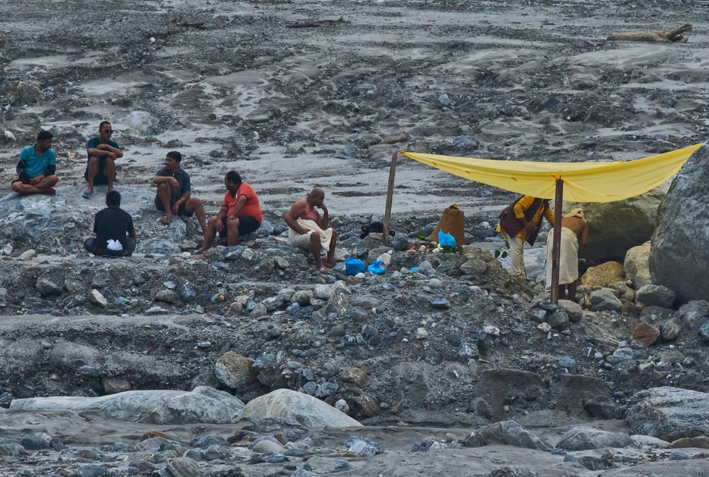 Nepalese people perform religious rituals on the bank of Trishuli river at Dunge in Nuwakot, Nepal on Wednesday 23 September (AP)