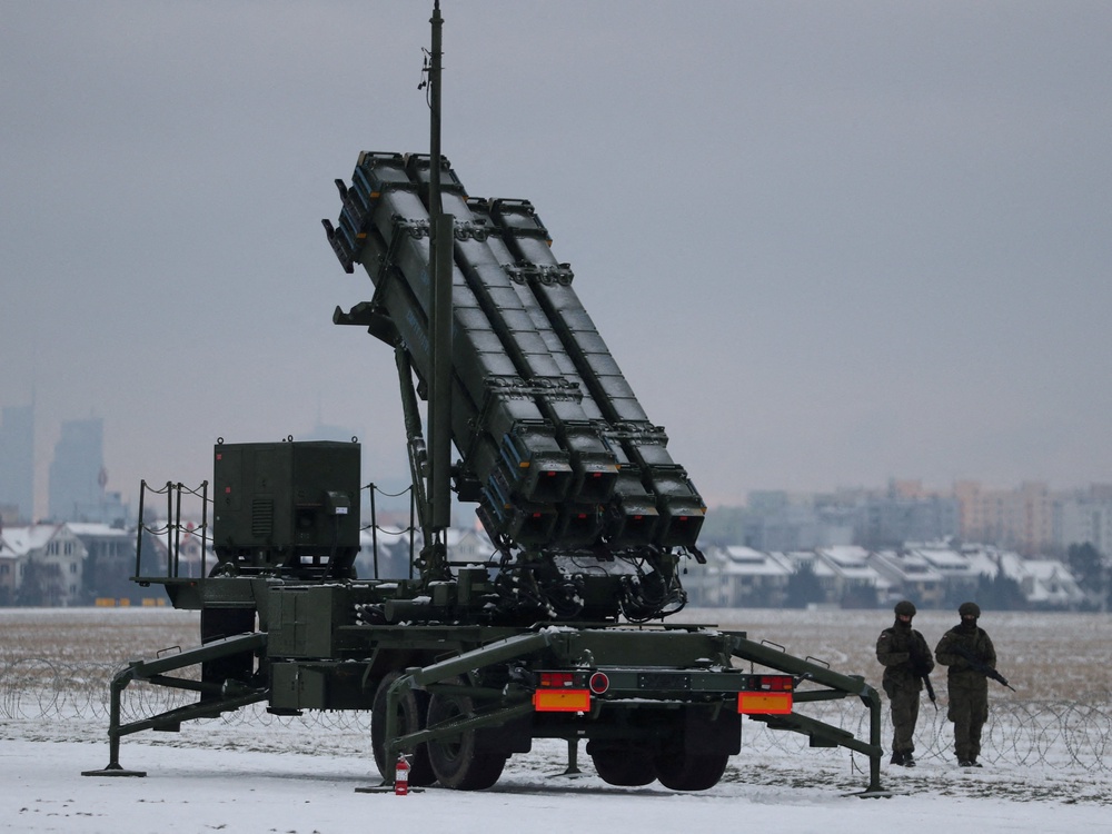 Servicemen patrol in front of the Patriot air defence system during Polish military training on the missile systems at the airport in Warsaw, Poland (Reuters)