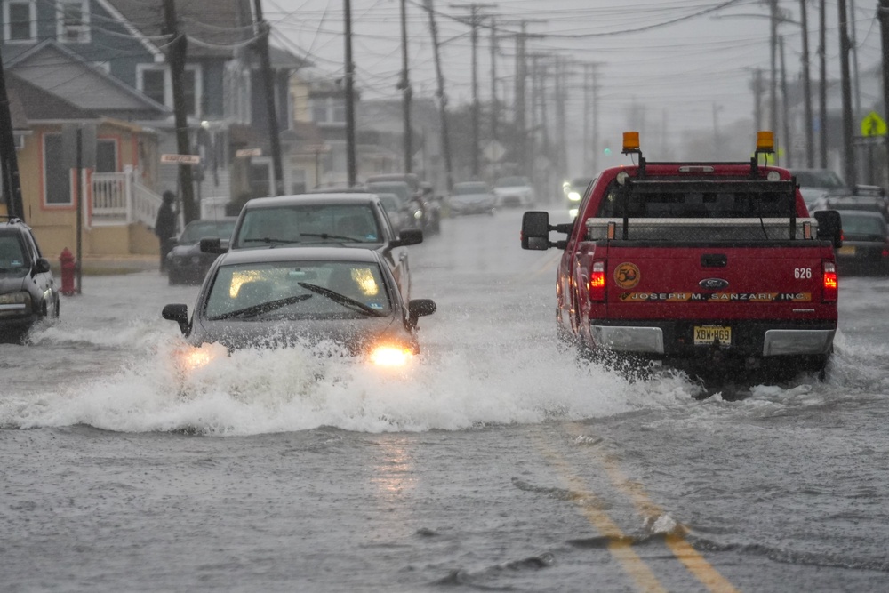 Cars drive through a flooded road in Point Pleasant (Getty Images)