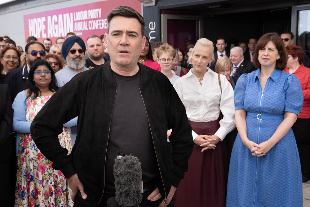 Andy Burnham speaks to the media as he and his wife Marie-France Van Heel arrive for the Labour Party Conference at the ACC Liverpool (PA)