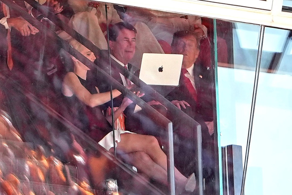 White House aide Natalie Harp, left, holds up a laptop for Trump, right, and Sen. Bill Hagerty, R-Tenn., center, during the game (AP Photo/Julia Demaree Nikhinson)