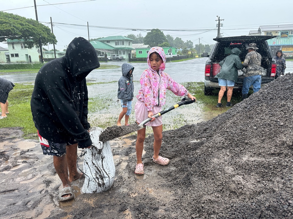 Kenzielynn Kekoa, center, of Hilo, Hawaii, helps her family fill sand bags as Hurricane Nolo approaches in Hilo (Copyright 2026 The Associated Press. All rights reserved)