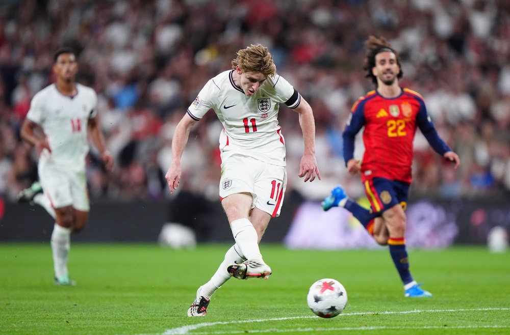 Anthony Gordon slides home England's first goal of the game (PA)