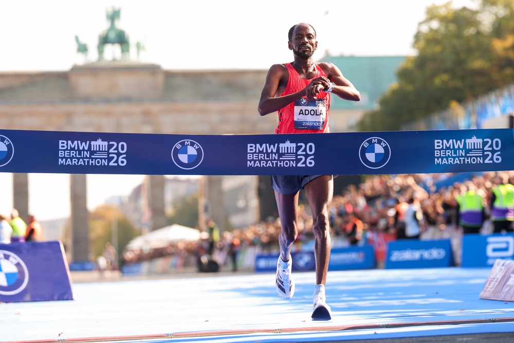 Guye Adola from Ethiopia celebrates crossing the line (Getty)