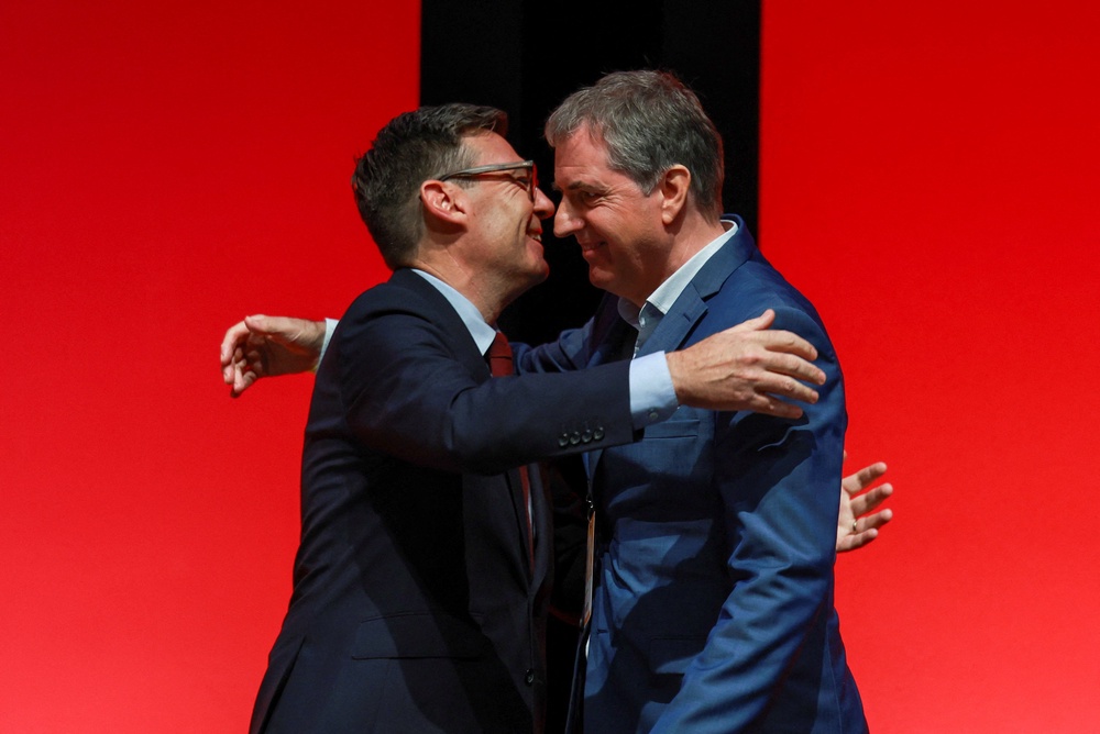 Andy Burnham hugs mayor of the Liverpool City Region, Steve Rotheram, during the Britain's Labour Party's annual conference in Liverpool (Reuters)