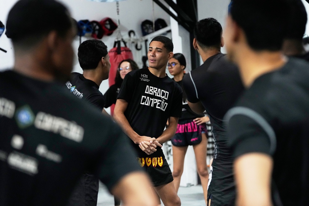 Youth attend a martial arts class at Abraco Campeao, or Embrace Champions, an academy that offers free boxing, jiu-jitsu, Muay Thai and capoeira classes, as well as educational talks on topics ranging from environmental issues to relationships, in the Complexo de Alemao favela in Rio de Janeiro, Wednesday, Sept. 16, 2026 (AP Photo/Silvia Izquierdo)