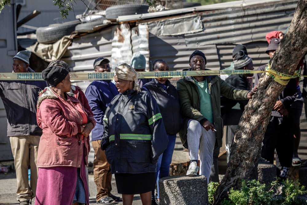 Bystanders look on behind police tape near an entertainment venue in Somerset West on September 27, 2026, after gunmen stormed the premises (AFP/Getty)