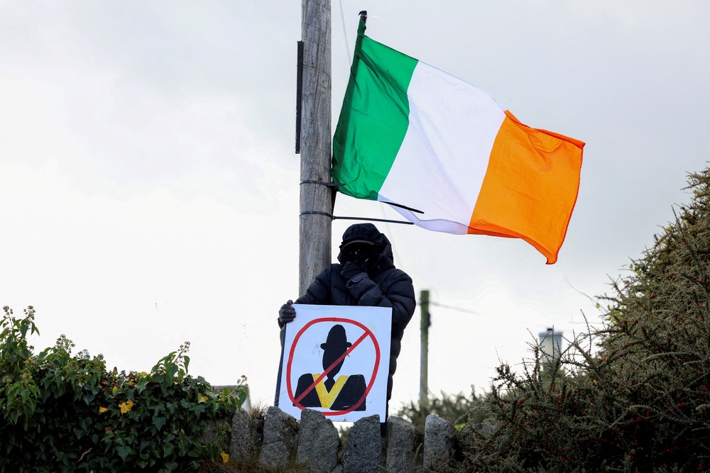 A demonstrator holds a placard as people protest on the Garvaghy Road (Reuters)