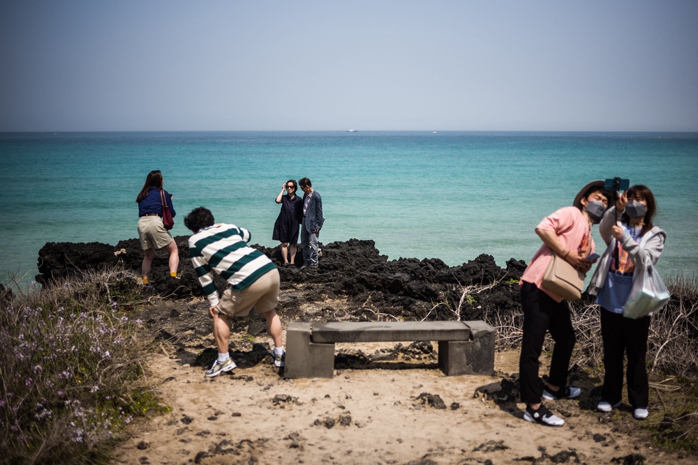 File: Visitors take photos near Hamdeok beach in Jeju City, on South Korea's largest island of Jeju (AFP/Getty)