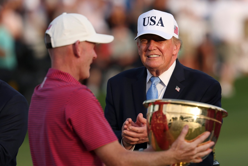 Donald Trump cheered on the golf green as Brandt Snedeker was awarded the President's Cup trophy (Getty)