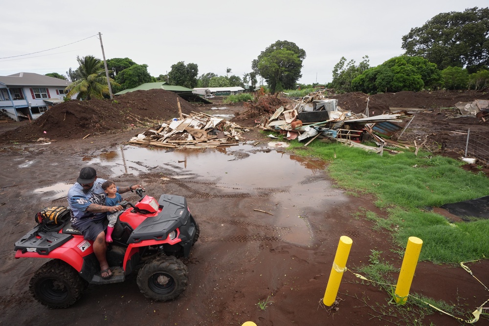 A man rides with his son near where a home was destroyed during last month's Hurricane Lala, as floodwaters from Hurricane Nolo recedes Sunday, Sept. 27, 2026, in Naalehu, Hawaii (Copyright 2026 The Associated Press. All rights reserved)