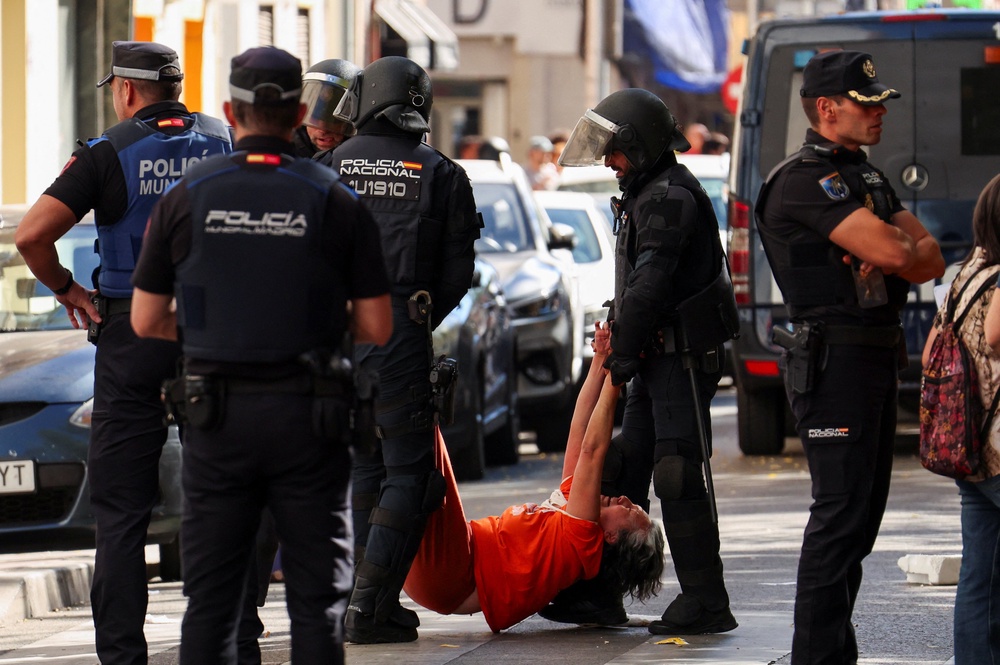 Spanish riot police removes one of the activists, who were trying to prevent the eviction of Maricarmen Abascal, 87 (Reuters)