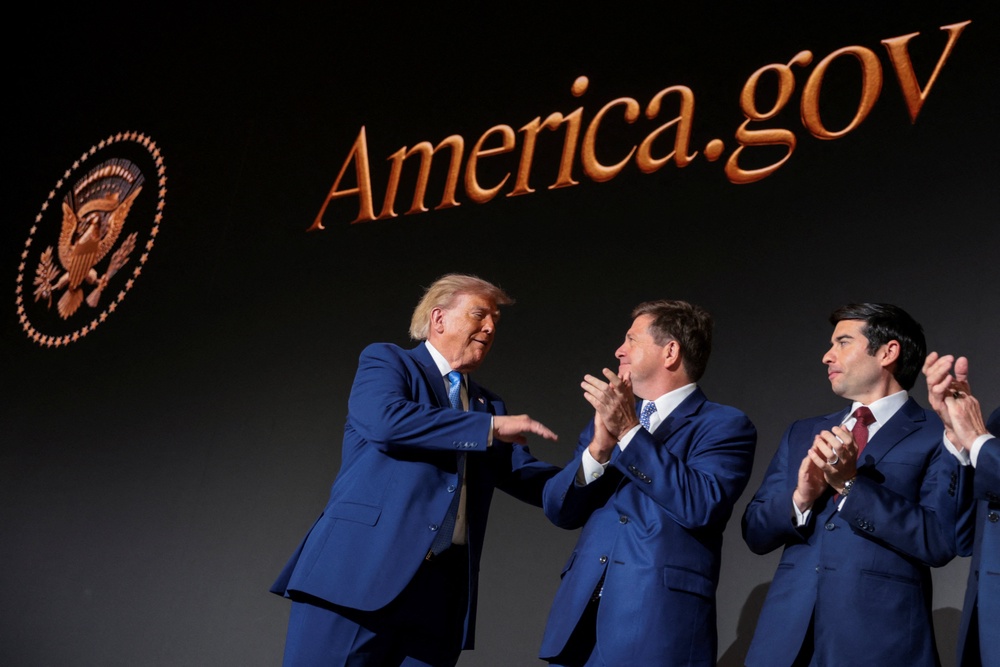 Donald Trump congratulates members of the National Design Studio at the launch of America.gov (Reuters)