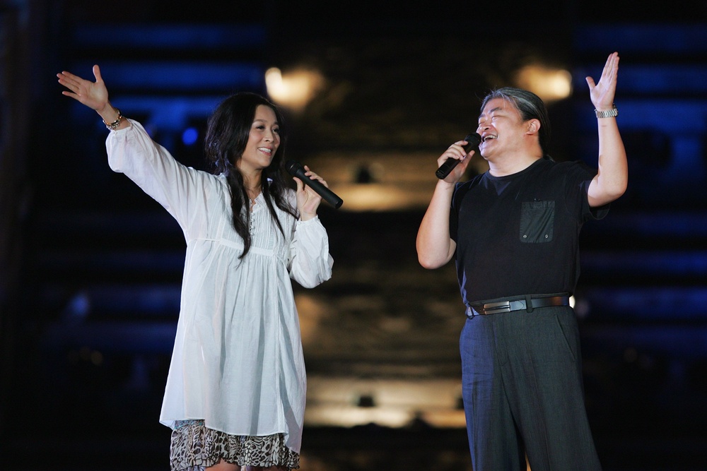 Chinese singer Liu Huan (R) and Na Ying (L) perform during the Award-giving Ceremony for the 4th Olympic Songs Competition at the illuminated Worker People's Cultural Palace, the Imperial Ancestral Temple inside the Forbidden City, on April 30, 2008 in Beijing, China (Getty)