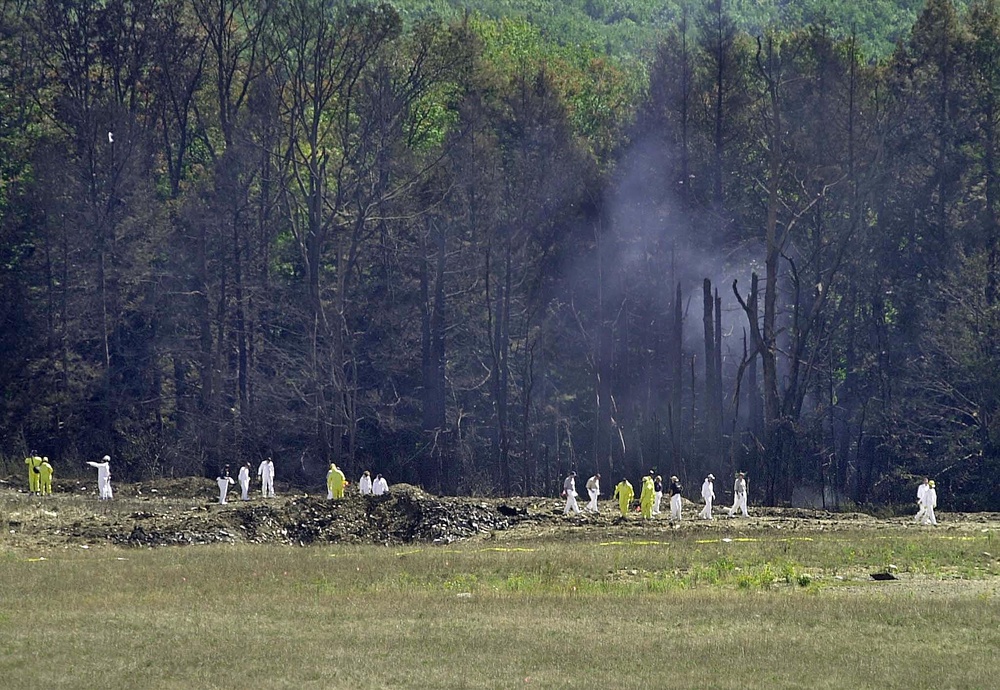 Investigative personnel search the crash site of United Airlines Flight 93 looking for debris and evidence, including the plane's flight recorder, 12 September 2001 in Shanksville, Pennsylvania. (AFP via Getty Images)