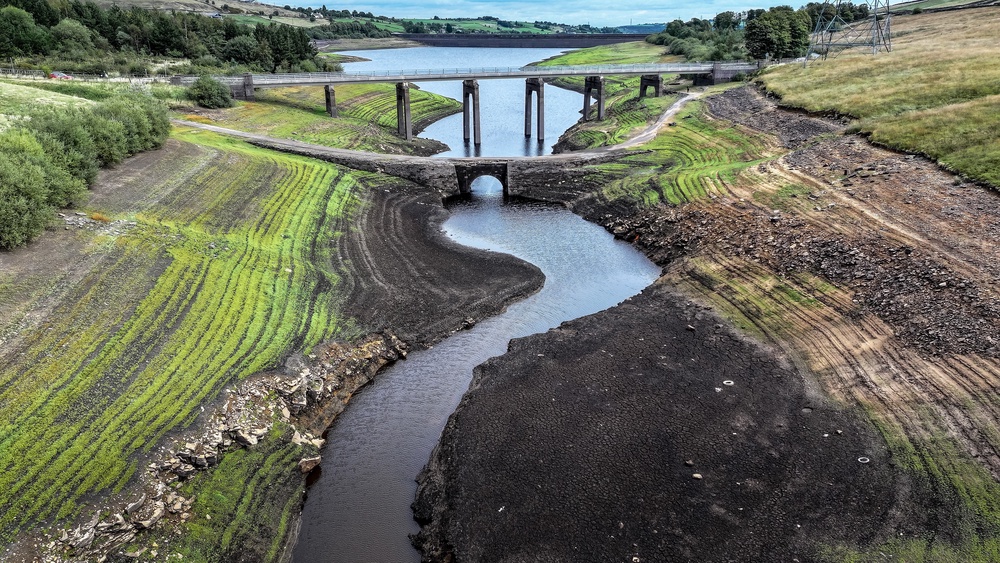 An ancient packhorse bridge is revealed by low water levels and allows vegetation to grow on the bed of Baitings Reservoir on September 14, 2026 near Ripponden, England (Getty)