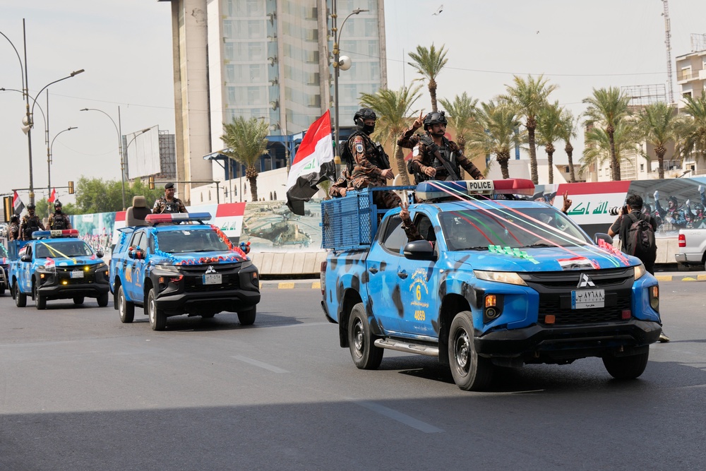 Iraqi police vehicles decorated with national flags and ribbons drive in a convoy as officers flash victory signs while celebrating the complete withdrawal of U.S. troops from Iraq (AP Photo/Hadi Mizban)