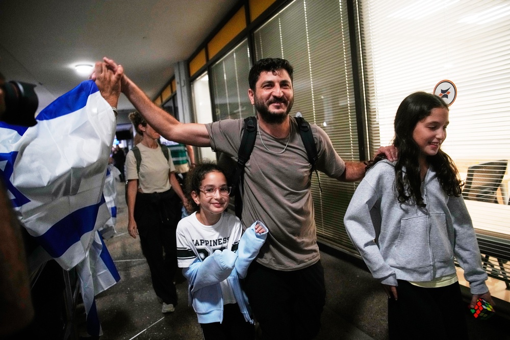 Israeli passengers who had been aboard a FlyDubai aircraft that made an emergency landing in Saudi Arabia are welcomed at the arrivals gate at Ben Gurion International Airport near Tel Aviv, Israel (AP)