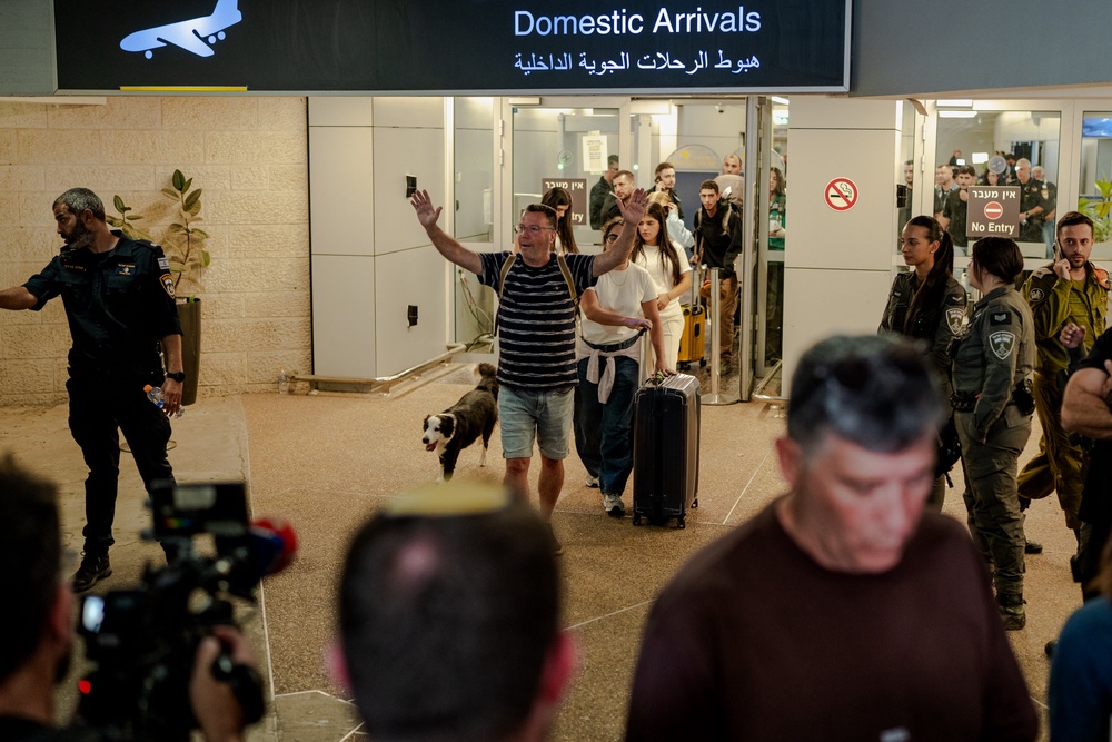 A passenger raises his arms in relief as he arrives in Ben Gurion Airport on Wednesday, after the Flydubai flight to Tel Aviv had to be diverted (Getty)