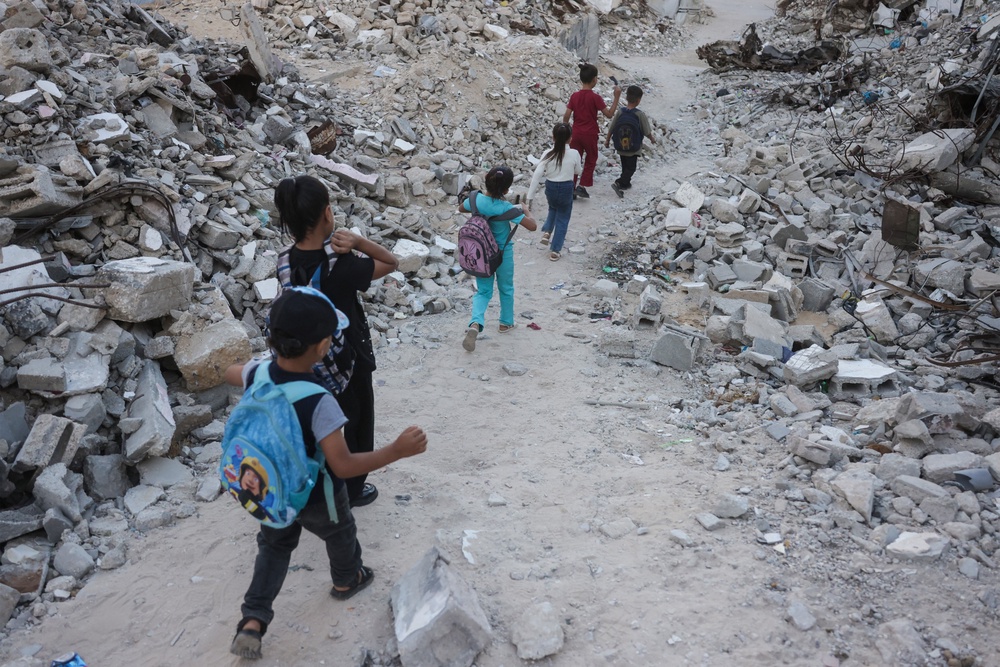Palestinian children walk to school amid the rubble of destroyed buildings as the academic year begins in Khan Yunis (AFP/Getty)