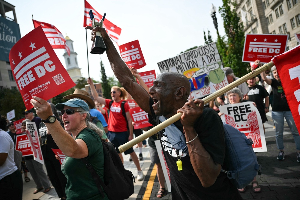 Demonstrators rally during a 'FreeDC' protest in Washington, DC, on August 11 to mark one year since President Trump deployed members of the National Guard into the city (AFP via Getty Images)
