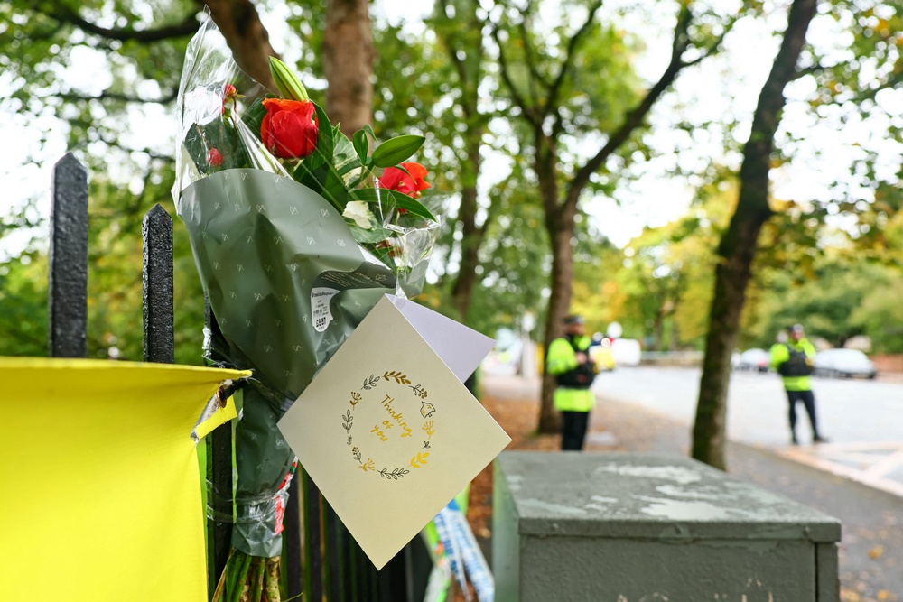 Flowers and messages of condolence are pictured by a Police cordon on the main road outside Heaton Park Hebrew Congregation synagogue (AFP/Getty)