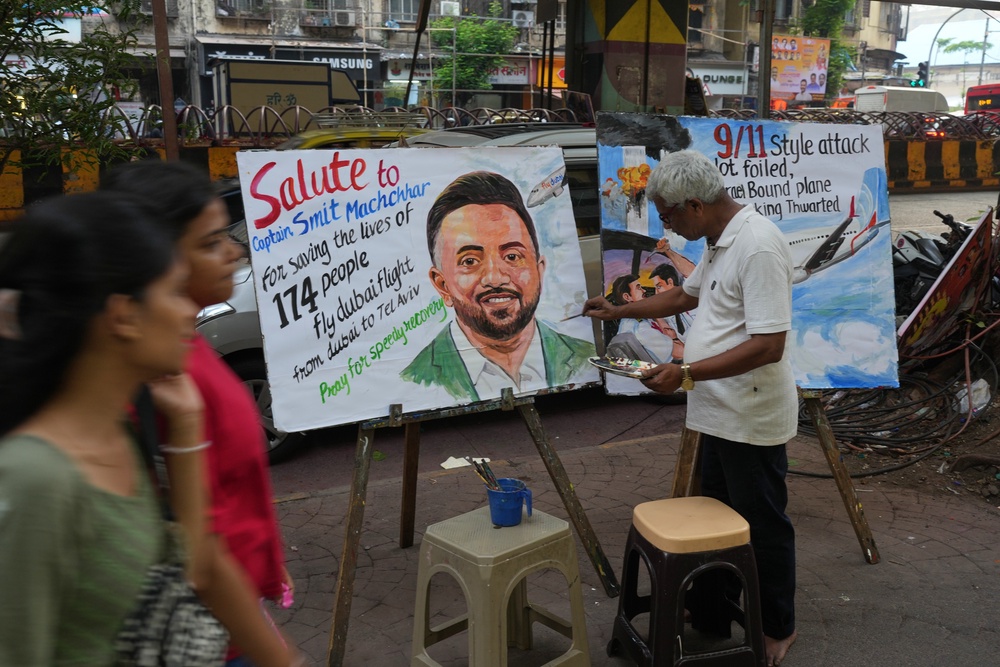 A teacher from Gurukul School of Art paints a portrait honoring Smit Machchhar,, an Indian pilot with FlyDubai, in Mumbai, India, Thursday, Oct. 1, 2026.(AP Photo/Rafiq Maqbool) (AP)